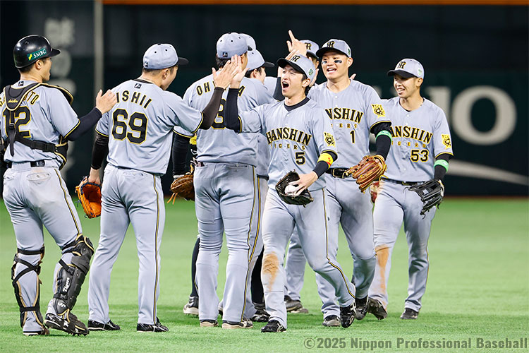 シリーズを先勝し、タッチを交わす阪神ナイン